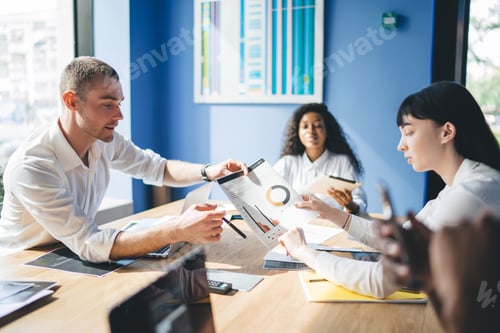 Preview: Elegant multiethnic coworkers discussing document in conference room
