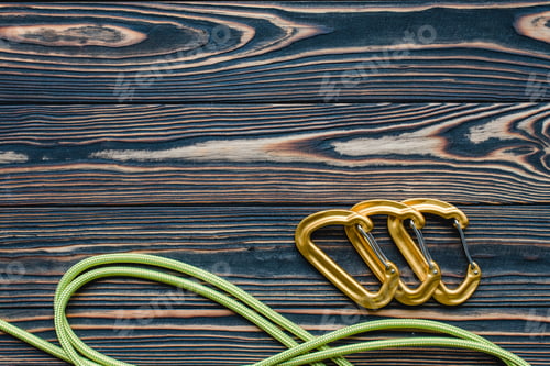 Preview: Isolated photo of climbing equipment. Parts of carabiners lying on the wooden table