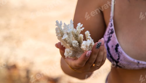 Preview: Coral in hands on the sea. Selective focus.