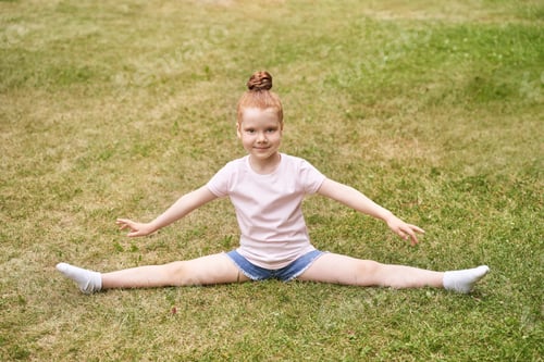 Preview: Pretty face. Red hair. Cute school child doing yoga exercise. Active vacation