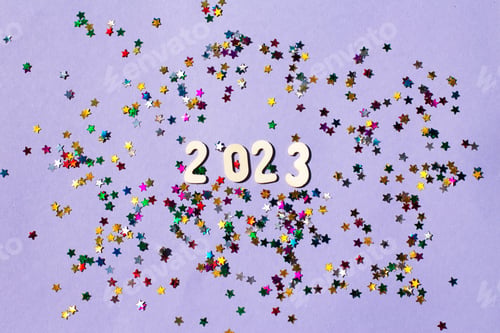 Preview: inscription 2023 with wooden numbers on purple background with multicolored confetti.Festive concept