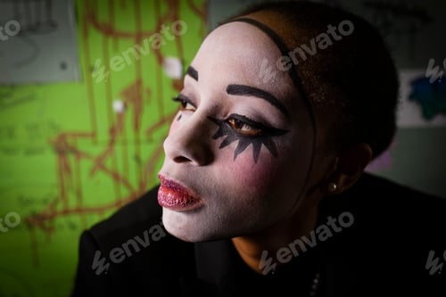 Preview: Portrait of young woman with face painted as pierrot