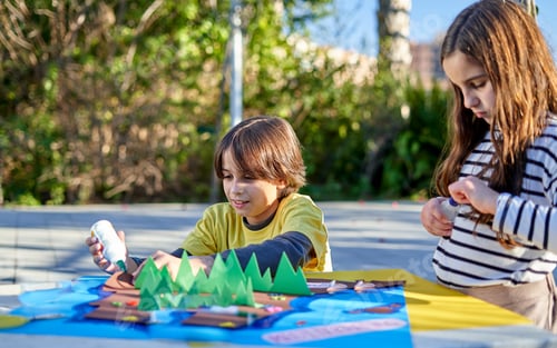 Preview: children doing crafts at a table in the park