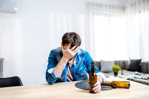 Preview: Drunk male alcoholic with drinks at home