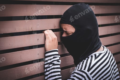 Preview: Robber hiding behind the wall, looking at victims and waiting to come nearest for stealing
