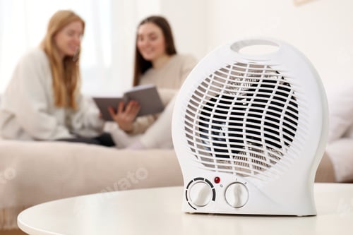 Preview: Women reading book in bedroom, focus on electric fan heater
