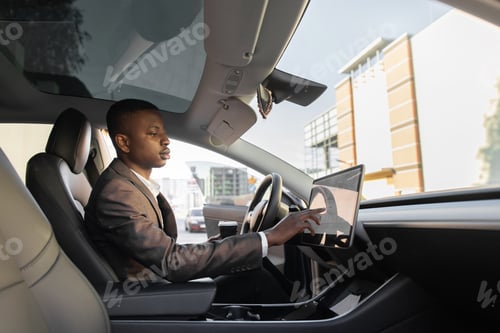 Preview: African American businessman touches the touchscreen in his new high-tech electric vehicle