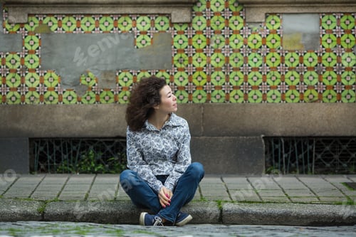 Preview: Asian Woman Sitting On The Sidewalk In Front Of Houses In Porto, Portugal.