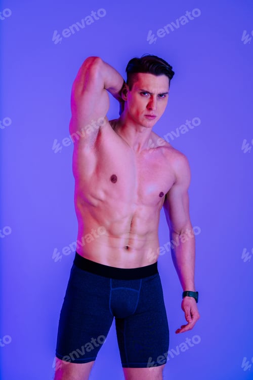 Preview: Athletic man with fit muscular body training in studio