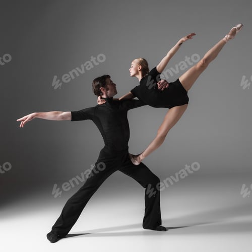 Preview: The Two Young Modern Ballet Dancers In Black Suits Posing Over Gray Studio Background
