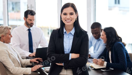 Preview: Shot of a young businesswoman standing with her arms crossed in a meeting at work