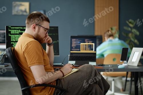 Preview: Young Adult Man Working on Software Development in Modern Office