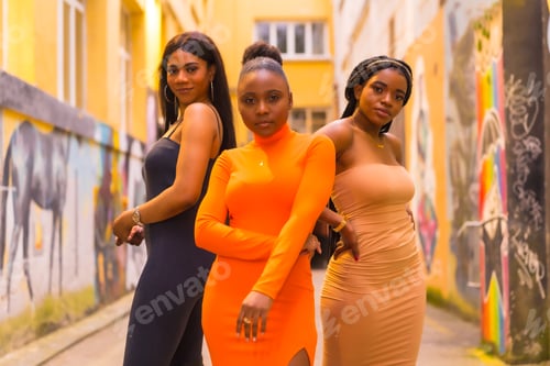 Preview: Urban style fashion with three black African girls on a city street