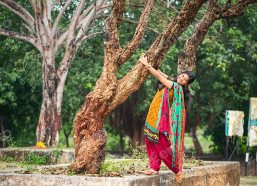 Preview: Young girl near tree trunk and she enjoying fresh air outdoors