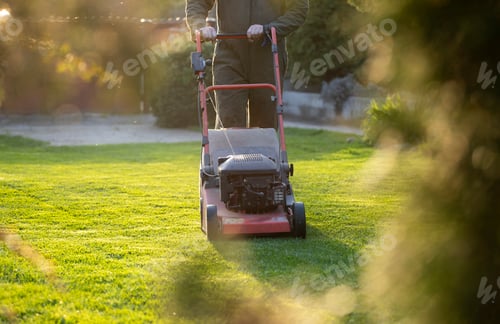 Preview: Garden worker with lawn mover. Garden works in spring.