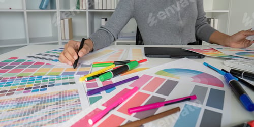 Preview: Creative Graphic Designer Working with Color Swatches and Design Tools in Modern Office Environment