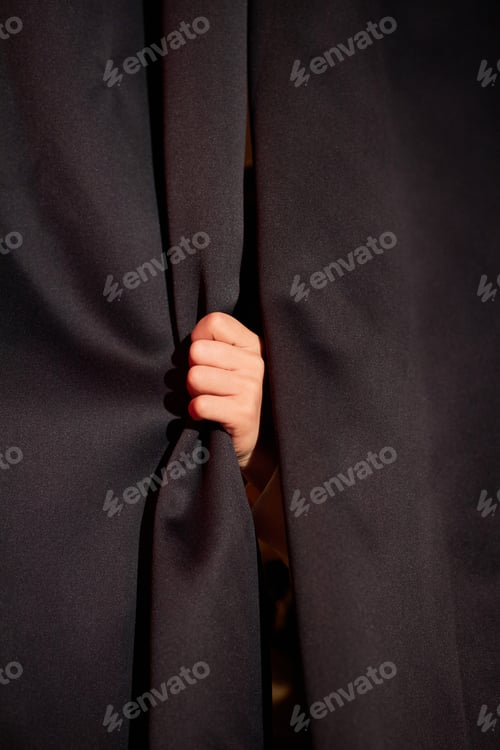 Preview: Childs Hand Holding Onto Curtain in Theater