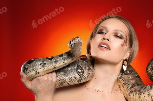 Preview: Beautiful woman with boa constrictor on bright colorful background