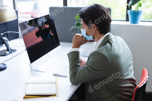 Preview: Caucasian man wearing face mask in an office