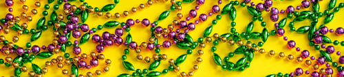 Preview: Mardi Gras concept. Multicolored beads on yellow background. Festive carnival symbols.