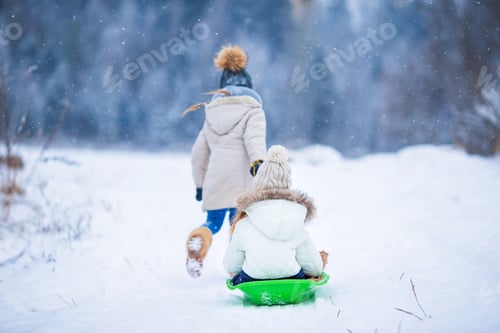 Preview: Little adorable girls enjoy a sleigh ride. Child sledding. Children play outdoors in snow. Family