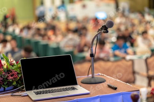Preview: Microphone and tecgnology laptopn on the table over the Abstract blurred photo of conference hall