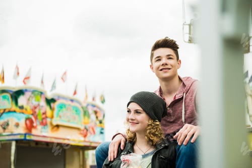 Preview: Portrait of happy teenage couple at fun fair