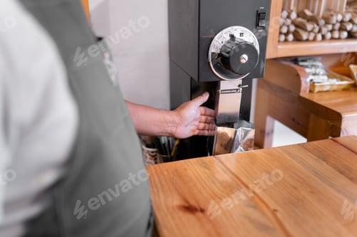 Preview: An Hispanic man hand is filling a bag with ground coffee