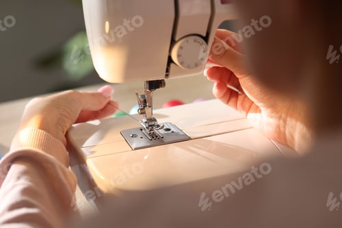 Preview: Woman threading sewing machine needle on blurred background, macro view