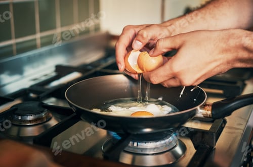 Preview: Its eggs for breakfast. Cropped shot of an unrecognizable man frying eggs in his kitchen at home.