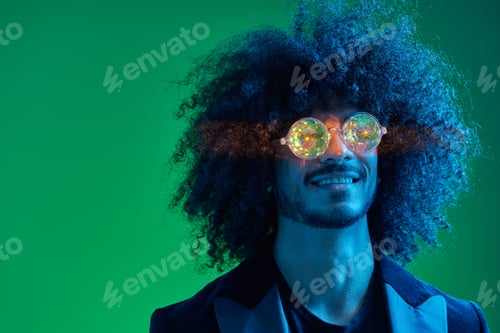 Preview: Fashion portrait of a man with curly hair on a green background with sunglasses, multinational