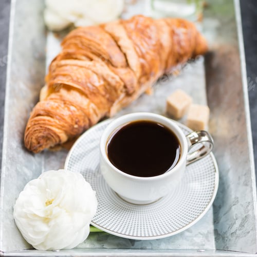 Preview: Fresh Croissant, Cup of Coffee and Ranunculus Flowers. Breakfast