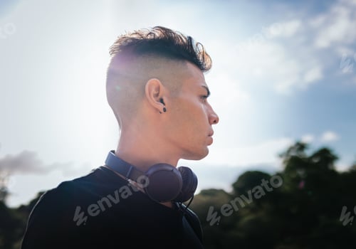 Preview: male in a black t-shirt with his earphones on his neck