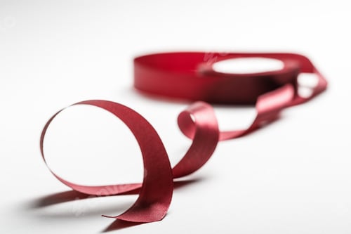 Preview: selective focus of satin wavy burgundy ribbon with spool on grey background