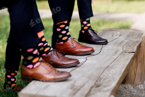 Preview: Feet of the groom and friends of the groom with funny colored socks. Men in colorful socks