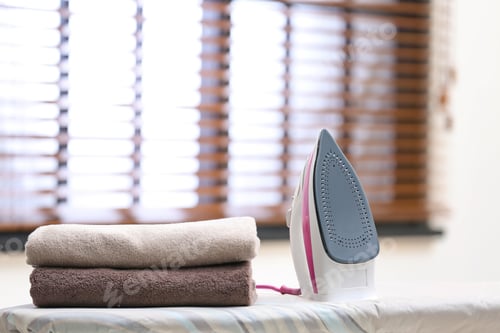 Vista previa: Modern iron and towels on board in room