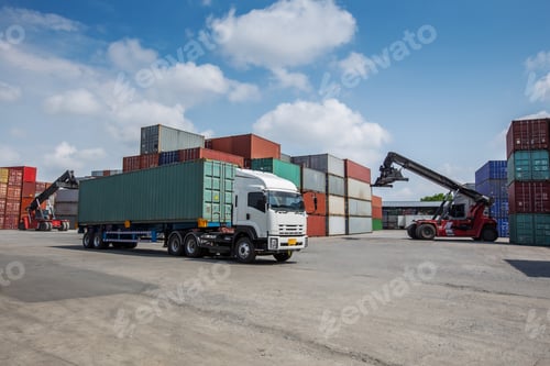 Preview: A red container forklift loads a cargo container onto a white truck in a busy shipping yard.