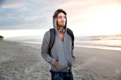 Preview: Young man on beach at sunrise