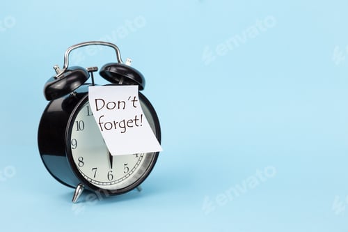 Preview: Black round alarm clock with a sticker with the inscription don't forget on a blue background