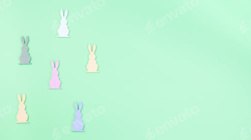 Preview: Green paper texture with colorful wooden Easter bunny figures, horizontal, copy space