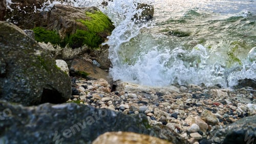 Preview: Sea waves rolling on beach and breaking over rocks and cliffs with growing seaweeds and algae