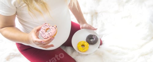 Preview: A pregnant woman eats sweet donuts. Selective Focus.