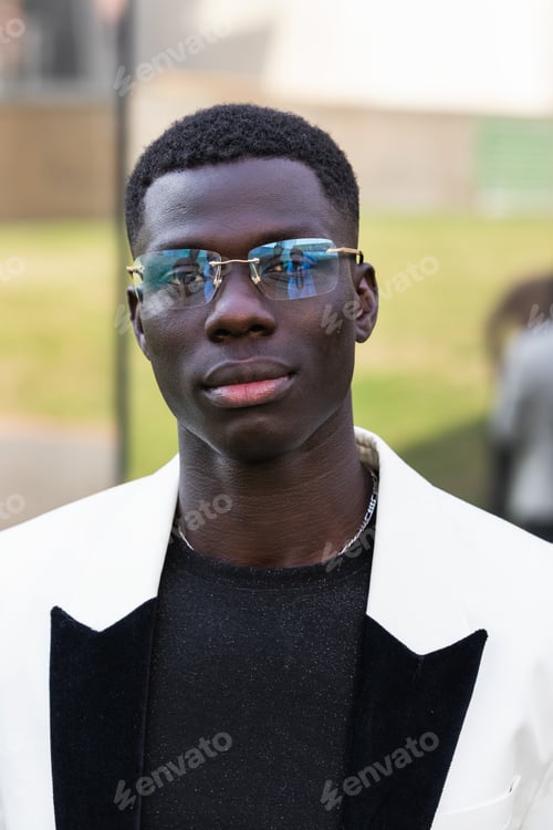 Preview: Stylish African American businessman in eyeglasses in town