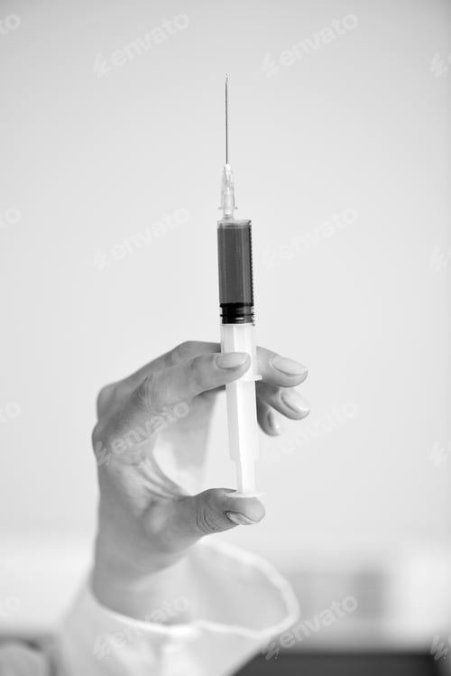 Preview: Close-up partial view of doctor holding syringe, black and white photo