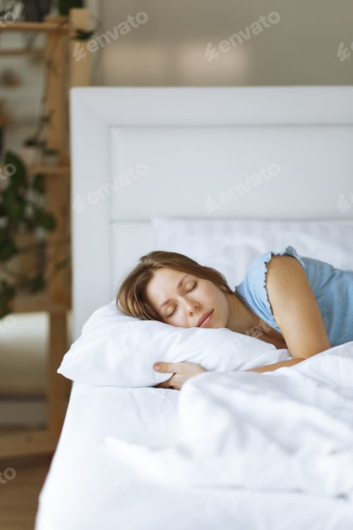 Preview: Close up portrait of sleeping young woman hugging pillow
