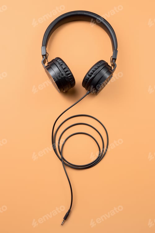 Preview: Photo of stylish modern black headphones over beige background.