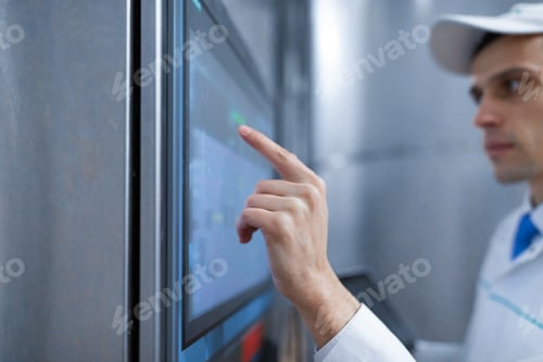 Preview: man in a white robe and a cap make a configure the digital screen
