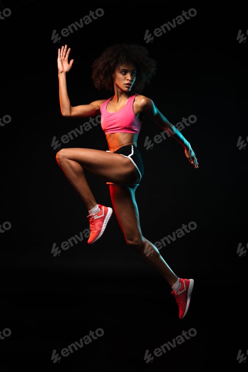 Preview: Image of nice african american sportswoman jumping while working out