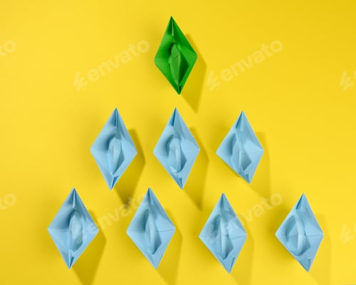 Preview: Group of paper boats on a yellow background. concept of a strong leader in a team