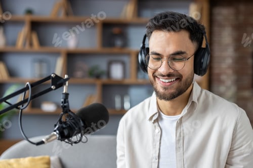 Vista previa: Smiling man in headphones recording podcast in studio with microphone, enjoying conversation and